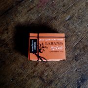 Embalagem Manufatura Poética com texto: sabonete artesanal de laranja, 100% vegetal e natural e silhueta de galho de laranjeira